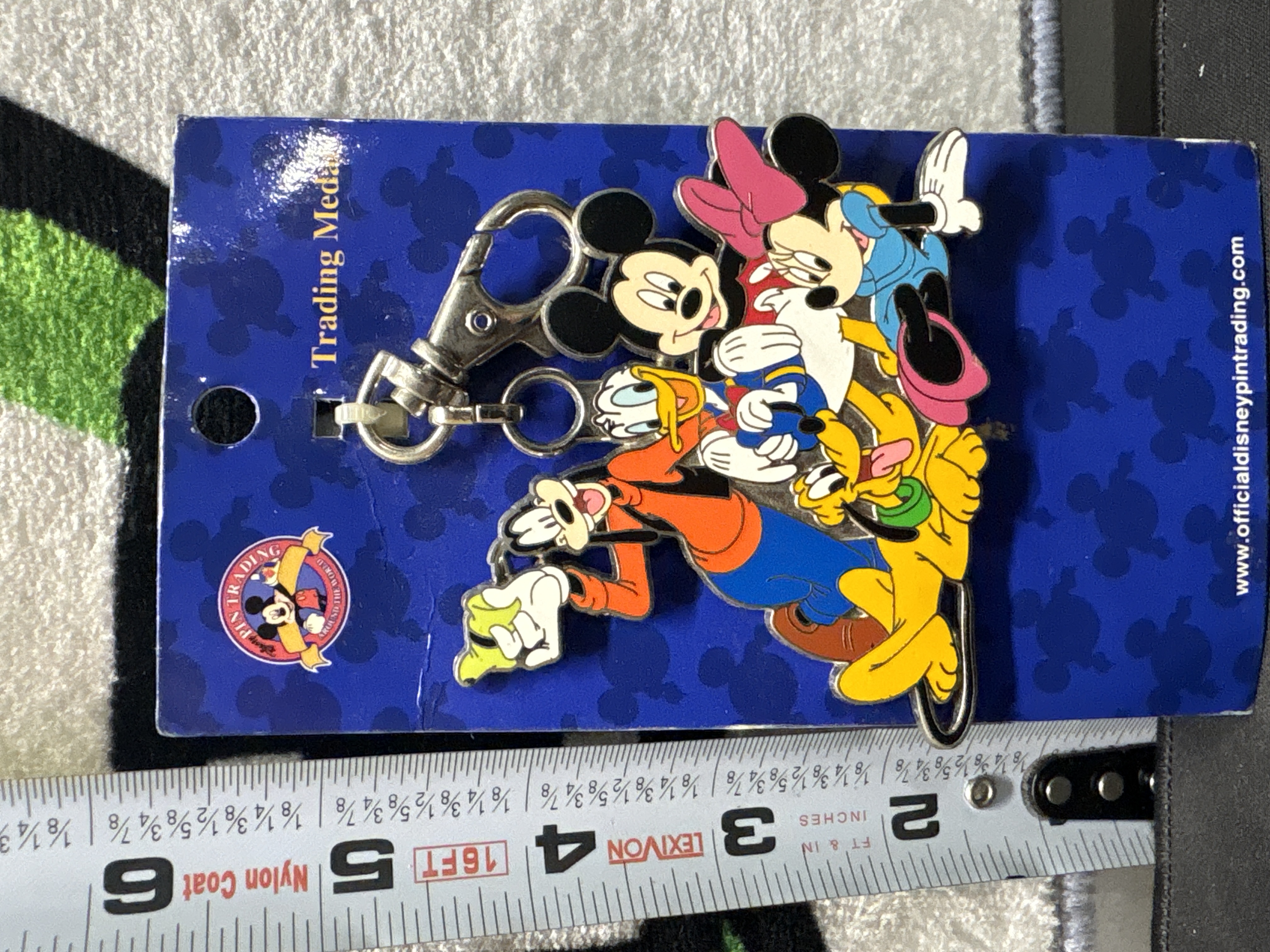 LOT 2026-980 — Épingle de collection Disney officielle « Pin Trading », présentée sur sa… — photo 1