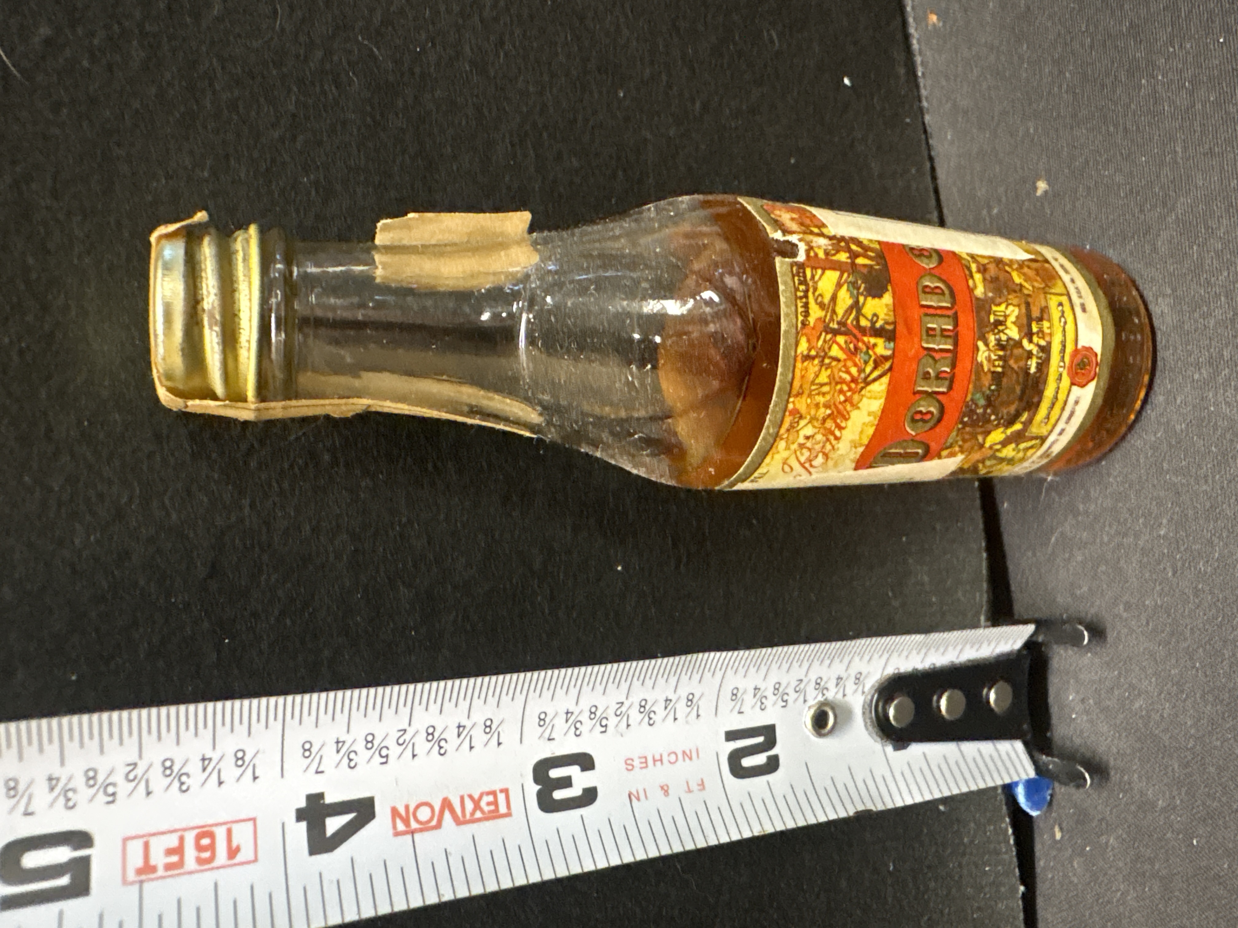 LOT 2026-558 — Petite bouteille en verre au contenu ambré, scellée et jamais ouverte selon… — photo 1