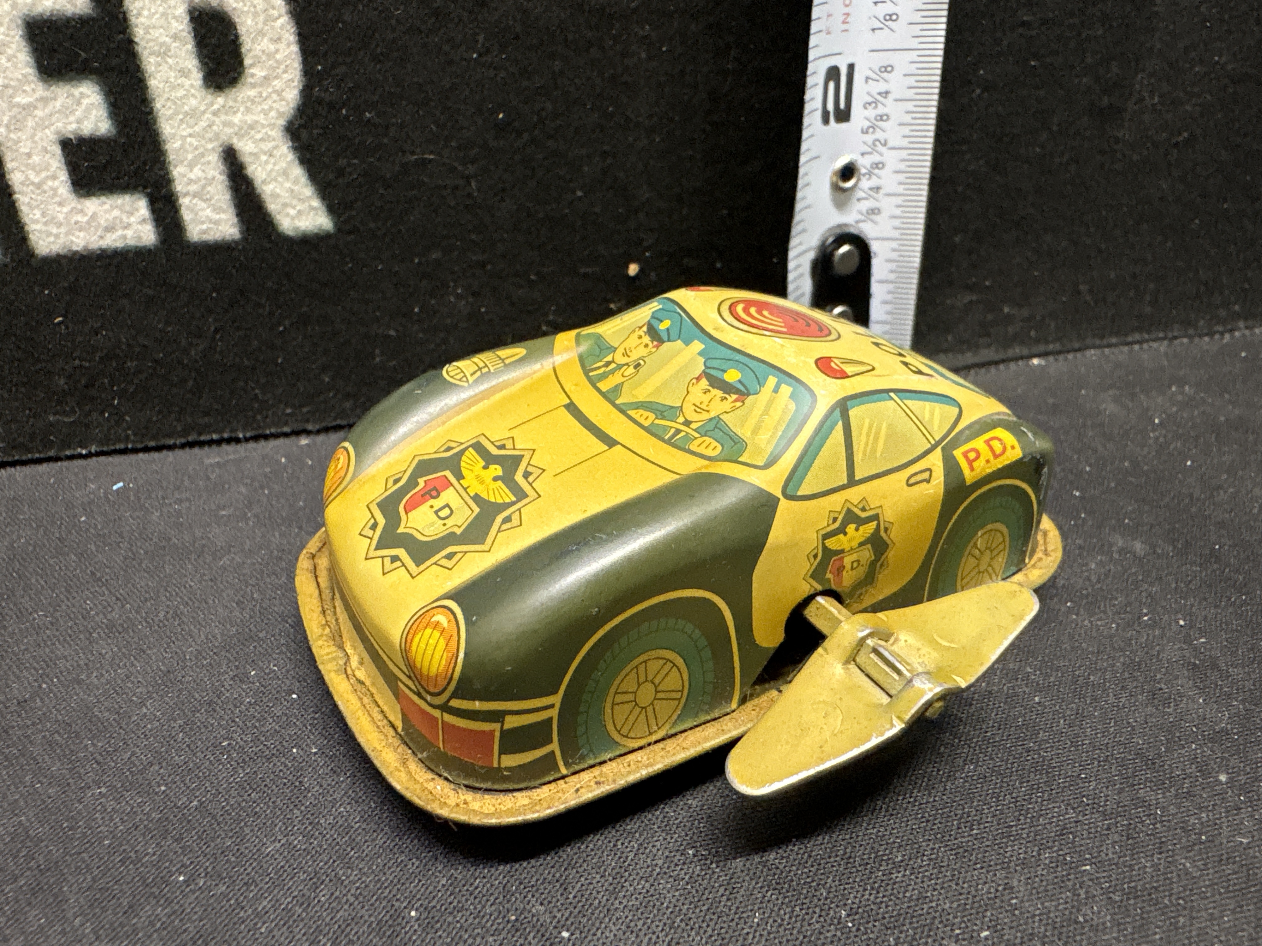 LOT 2026-582 — Petite voiture-jouet de police en métal lithographié, avec couleurs jaune et… — photo 2