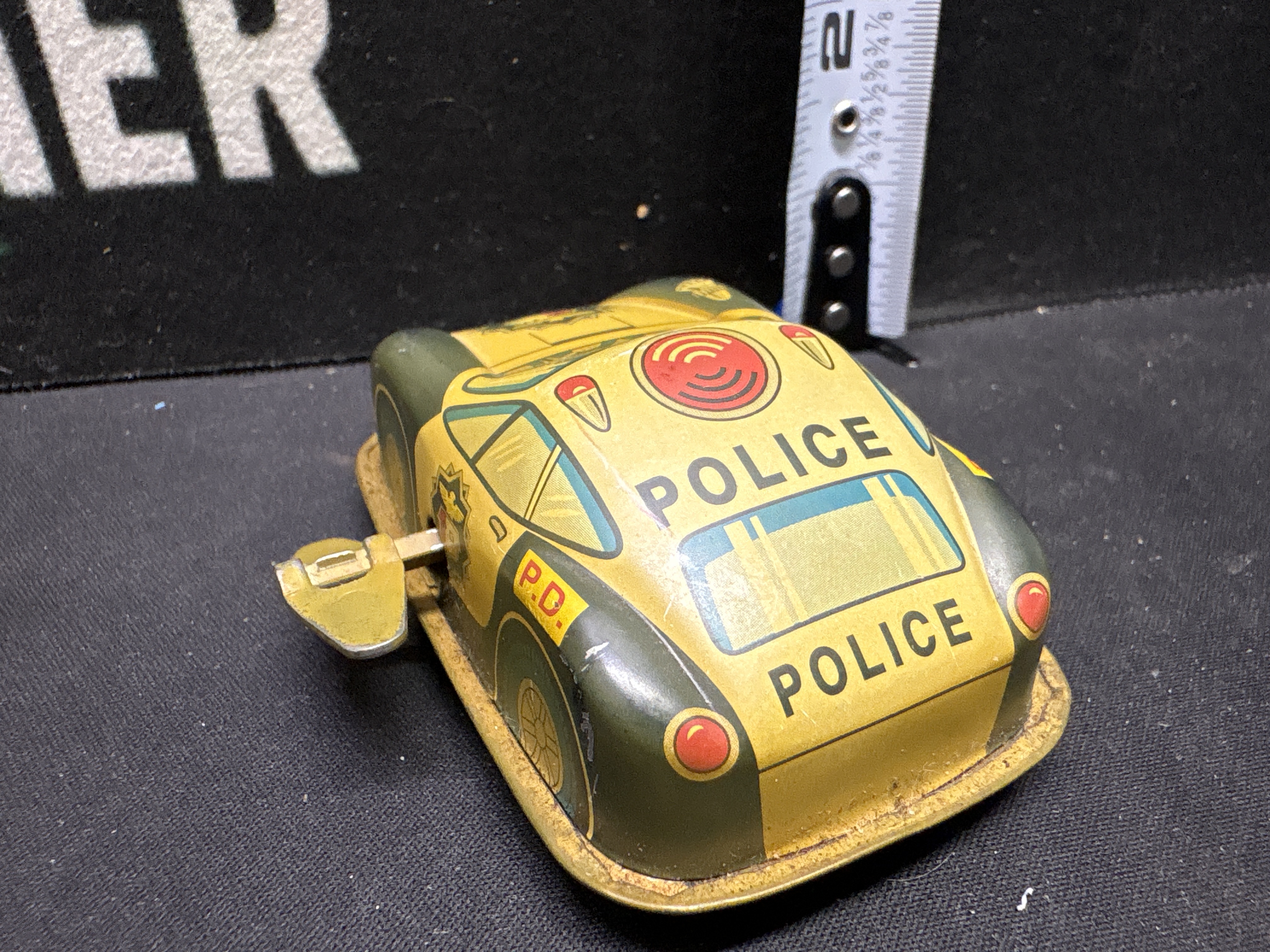 LOT 2026-582 — Petite voiture-jouet de police en métal lithographié, avec couleurs jaune et… — photo 3