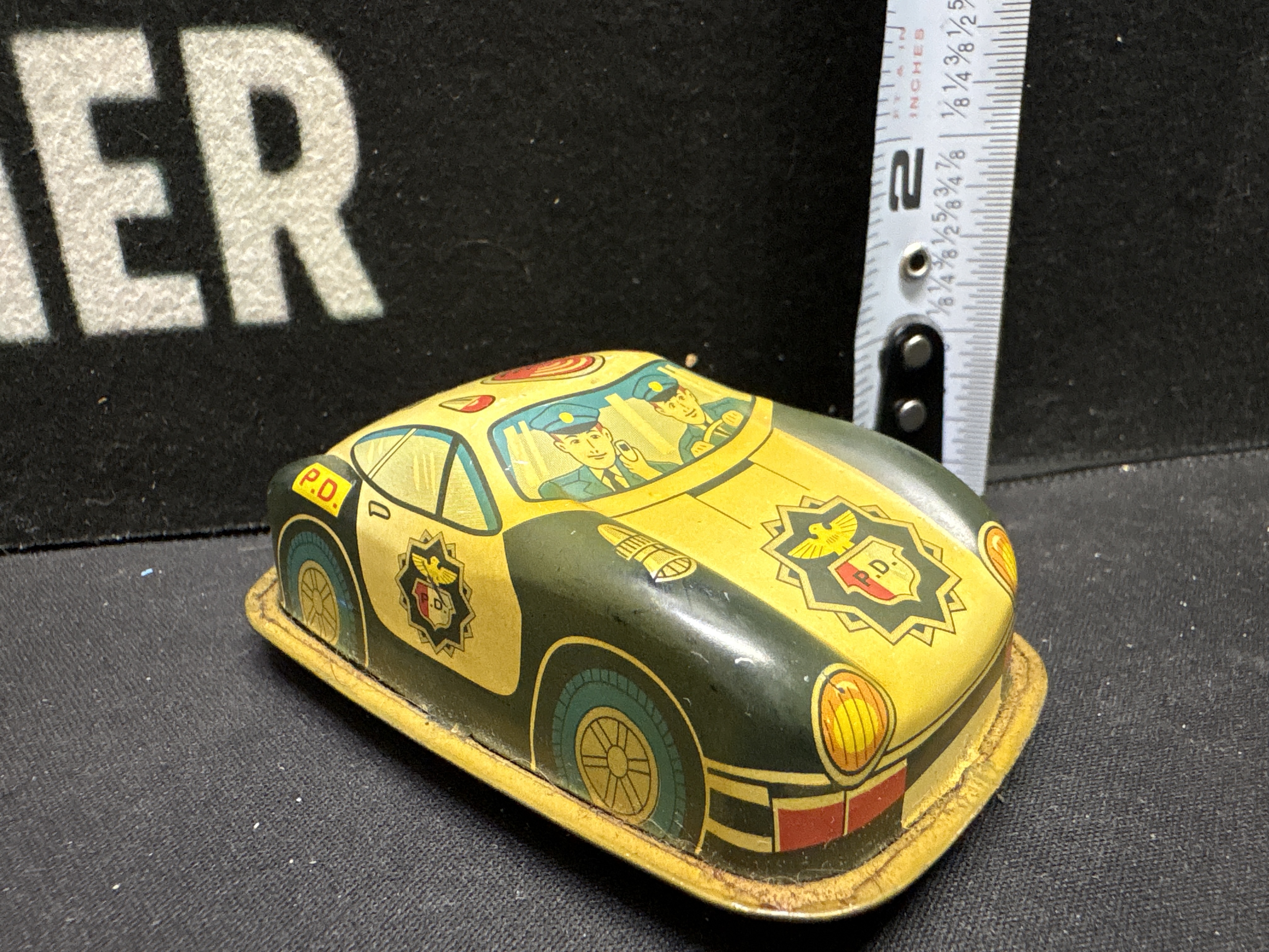LOT 2026-582 — Petite voiture-jouet de police en métal lithographié, avec couleurs jaune et… — photo 1