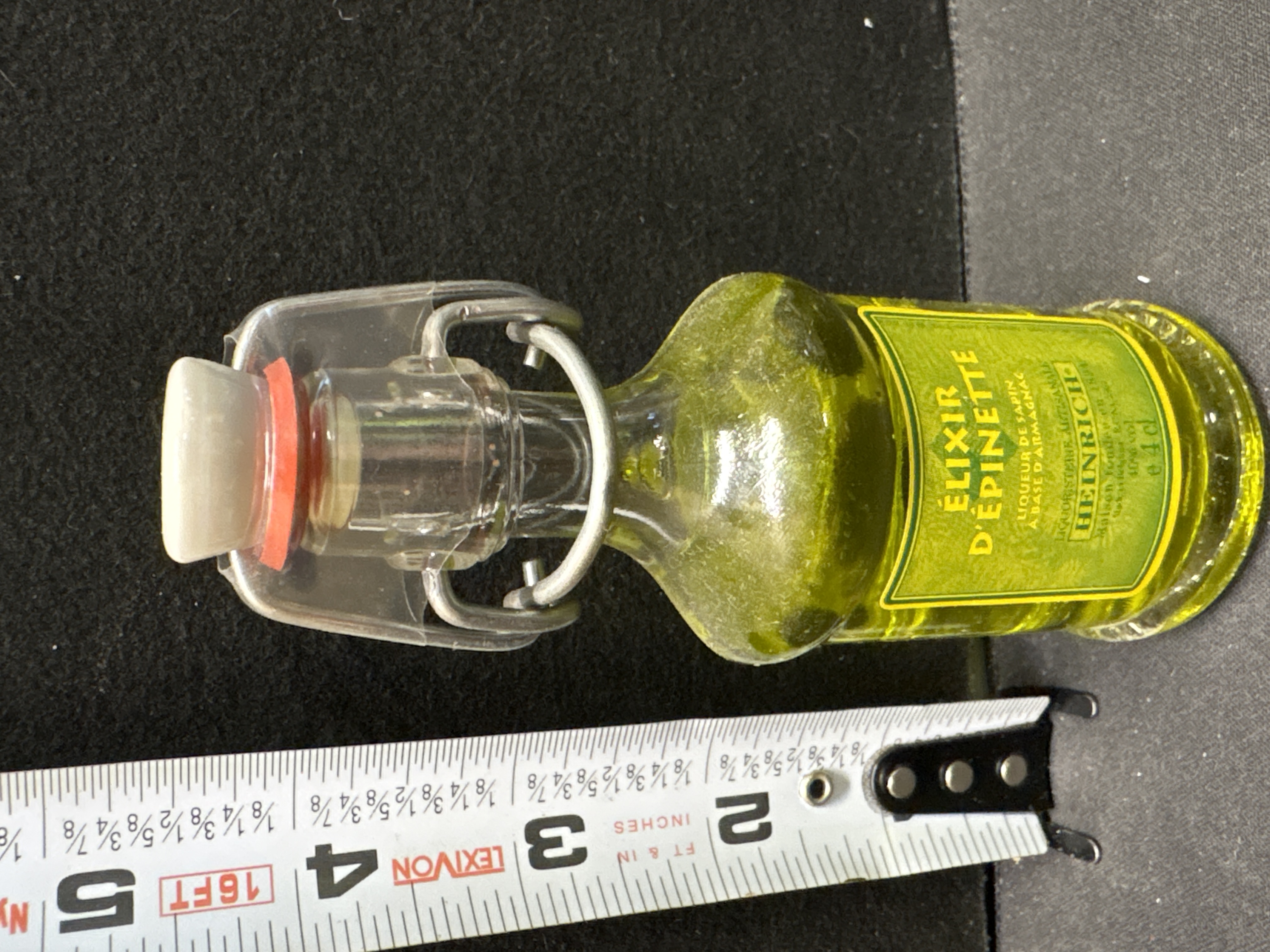 LOT 2026-705 — Bouteille en verre contenant un élixir d’épinette, identifié sur l’étiquette… — photo 1