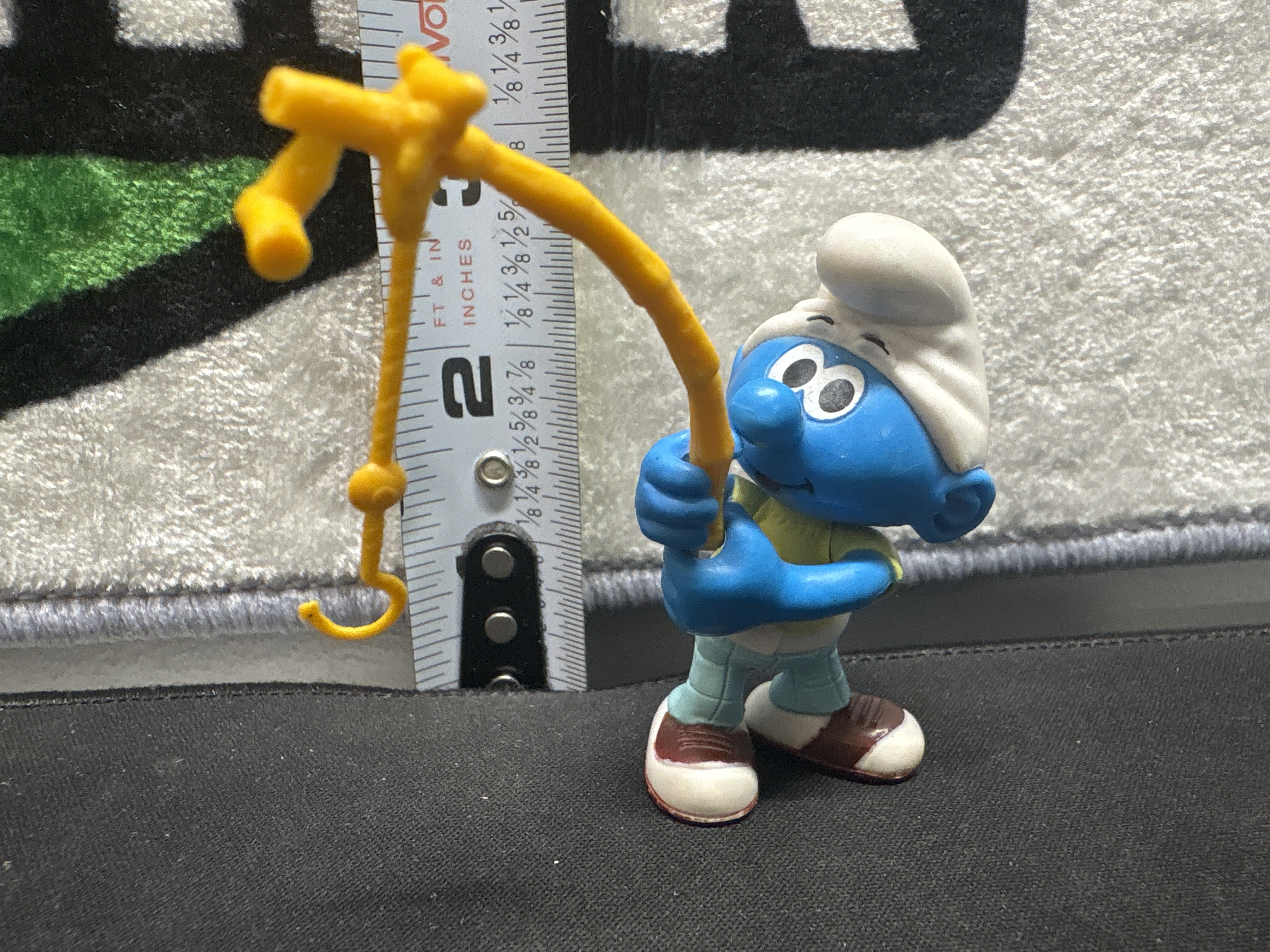 LOT 2026-840 — Figurine en plastique d’un Schtroumpf avec accessoire jaune, mesurant environ… — photo 1